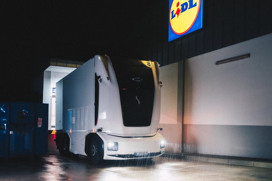Einride eBot, a white truck without a cab, at a Lidl store at night